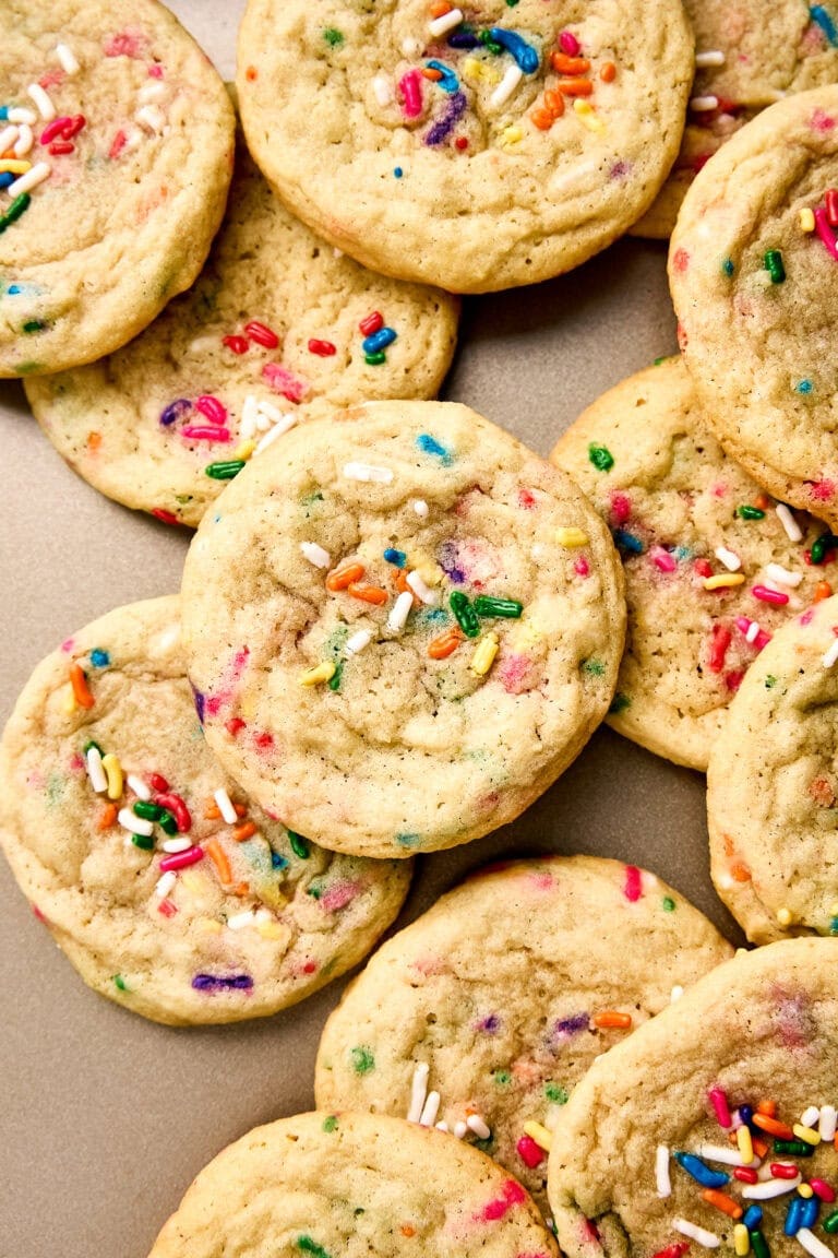 Close-up of soft, chewy funfetti cookies with colorful sprinkles on a neutral background.